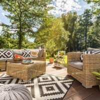 Terrasse mit Holzdielen und schwarzweißem Teppich