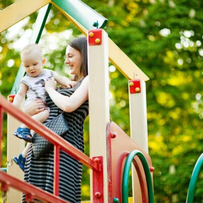 Mutter & Baby auf Kinder-Spielplatz